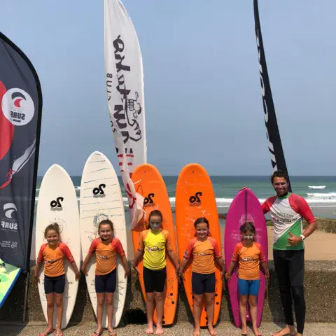 Groupe d'enfants avec leurs planches sur la plage de Bidart