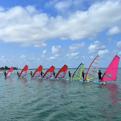 Rangée de planches à voile sur l'eau pendant un stage