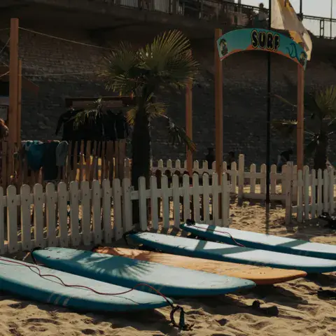Planches de paddle et de surf devant le club de plage
