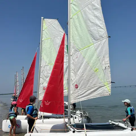 Catamarans de l'école mis à l'eau depuis la plage