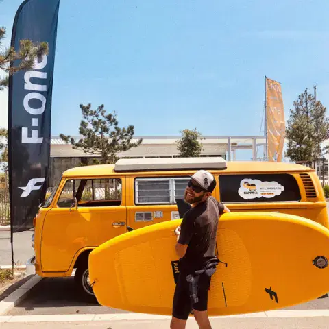 Combi VW jaune de l'école sur le parking du port
