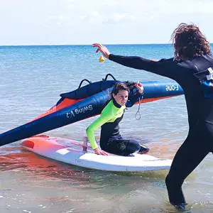 Cours de planche à voile avec un moniteur dans l'eau