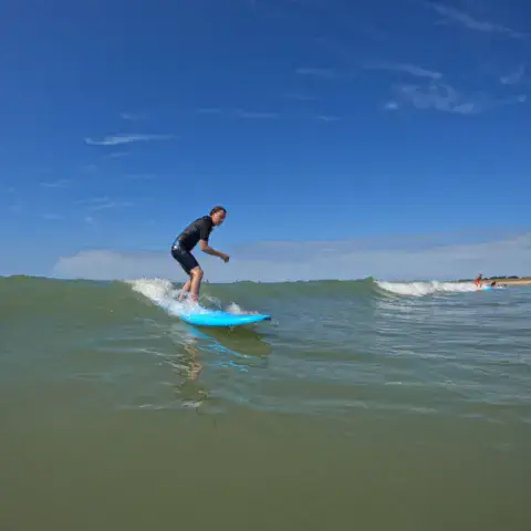 Surfeuse sur une vague de l'île de Ré