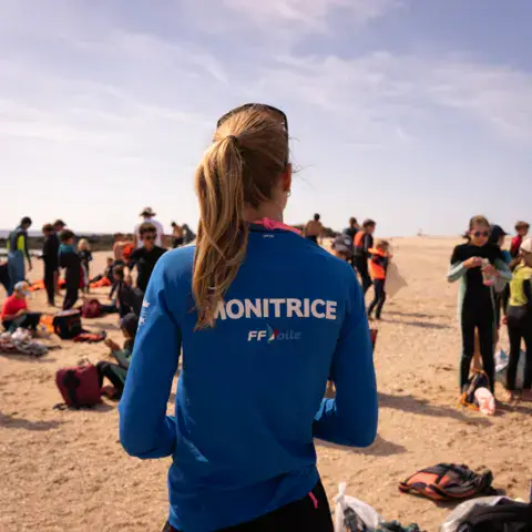 Monitrice et groupe d'élèves sur la plage avant la séance