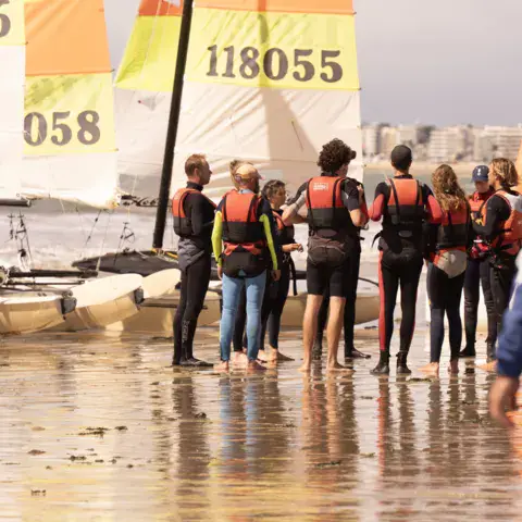 Briefing d'un groupe devant les catamarans