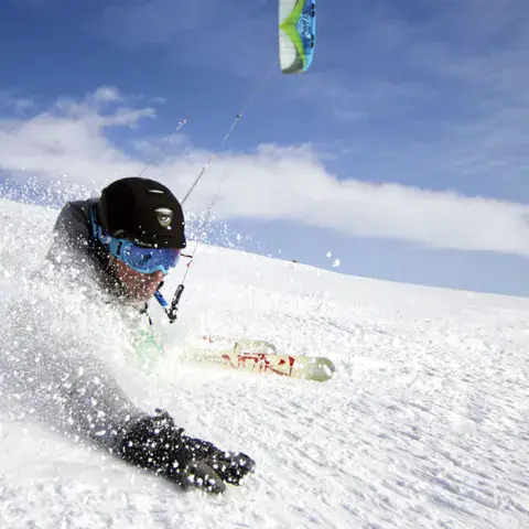 Snowkiter en poudreuse tracté par son kite