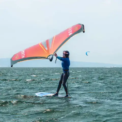 Élève en wing foil sur la lagune
