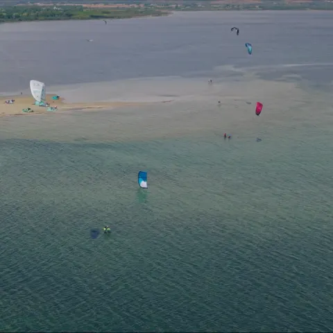 Kitesurfeurs sur l'eau plate de la lagune