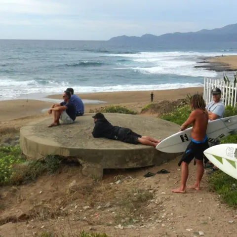 Surfeurs avec leurs planches sur la côte rocheuse et sableuse de Putzu Idu
