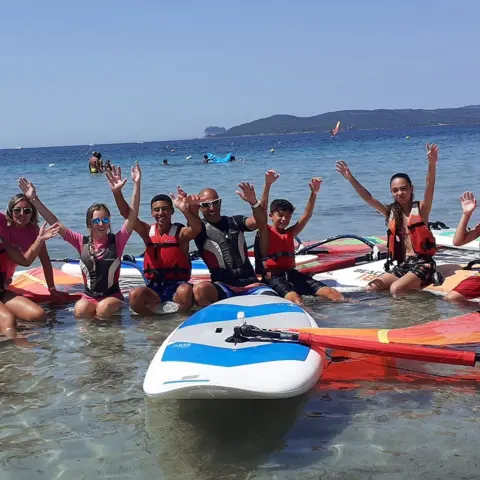 Élèves en gilet sur l'eau avec planches de windsurf et de SUP