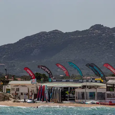 Le centre sur la plage, avec ses voiles de windsurf alignées
