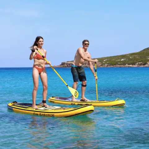 Deux pratiquants de stand up paddle près de la côte