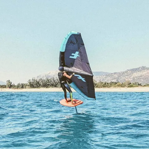 Rider en wing foil devant la côte