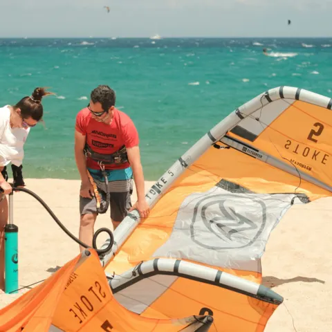 Préparation d'une aile de kite sur la plage avant un cours