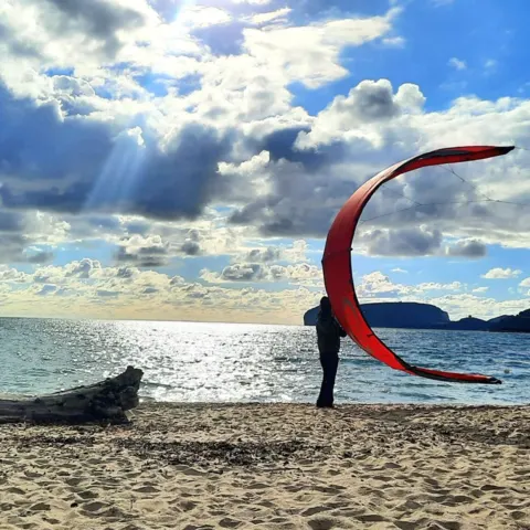 Aile de wingfoil déployée sur la plage