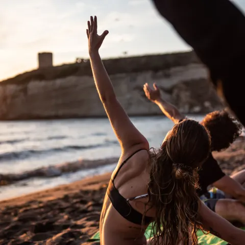 Séance de yoga sur la plage au coucher du soleil