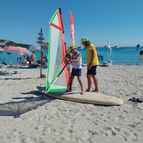 Moniteurs et planche de windsurf sur la plage de Marinella