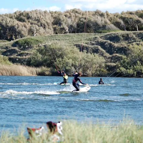 Kitesurfeurs sur la lagune, bordée de dunes