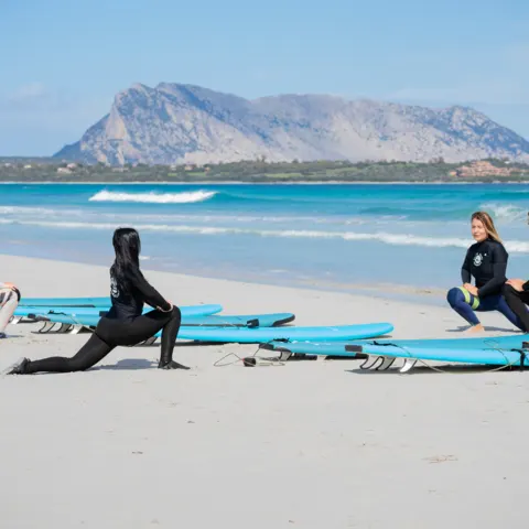 Échauffement d'un groupe de cours de surf sur le sable