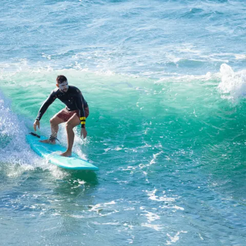 Élève de surf sur une vague