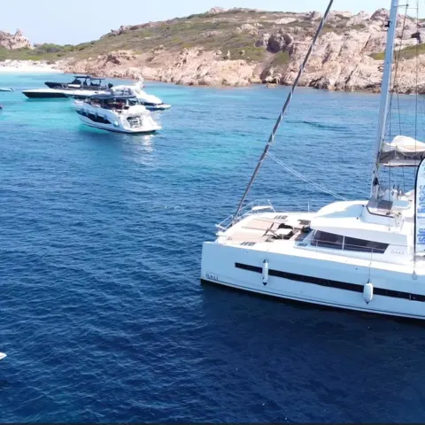 Rider en foil à côté du catamaran, au mouillage