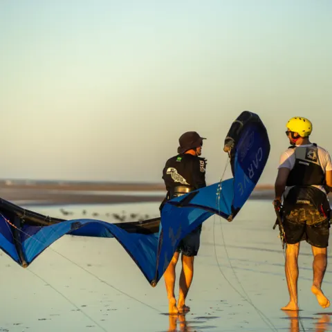 Moniteur et élève portant une aile sur la plage