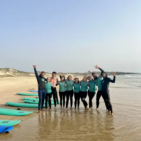 Groupe d'élèves en combinaison au bord de l'eau