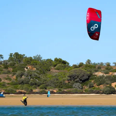 Rider sur la lagune avec un kite rouge