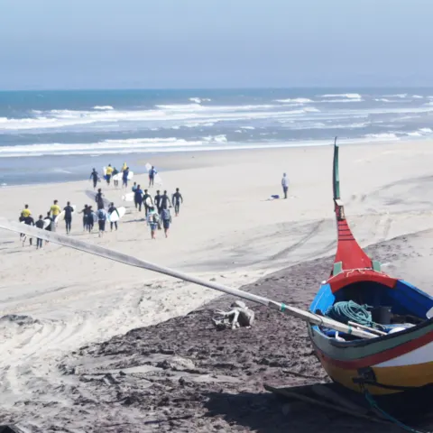 Groupe sur la plage près d'un bateau traditionnel