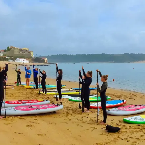 Échauffement d'un groupe de SUP sur la plage