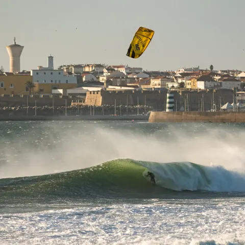 Kitesurfeur dans les vagues devant une ville côtière