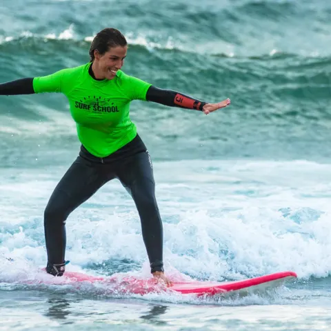 Élève debout sur sa planche dans les vagues de mousse