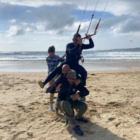 Groupe sur la plage avec un kite