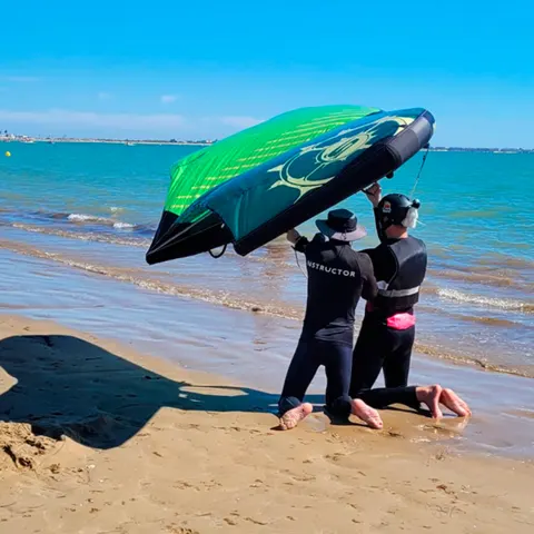 Instructeur et élève avec un wing sur le bord de l'eau