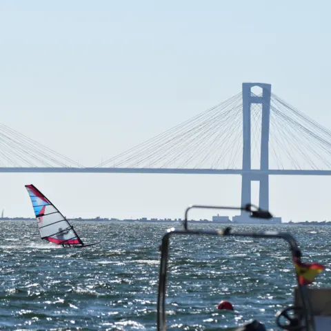 Planche à voile sur la ría, un pont en arrière-plan