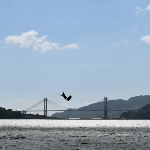 Saut en kitesurf, un pont en arrière-plan