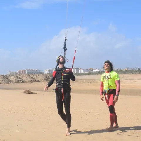 Cours de kitesurf sur la plage, moniteur et élève avec une barre