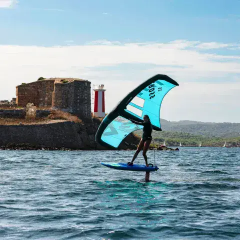 Rider de wing foil devant un fort