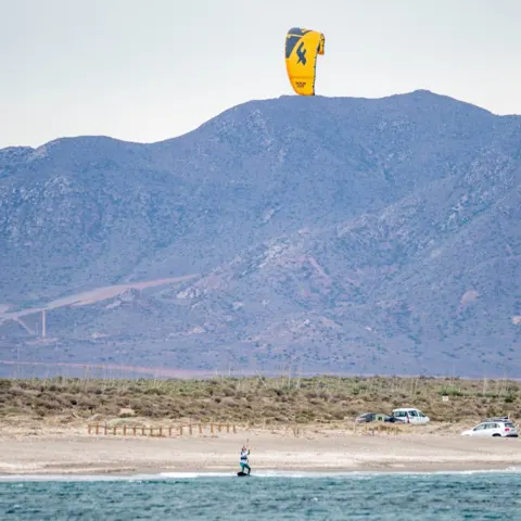 Kitesurfeur devant la côte, aile jaune en l'air