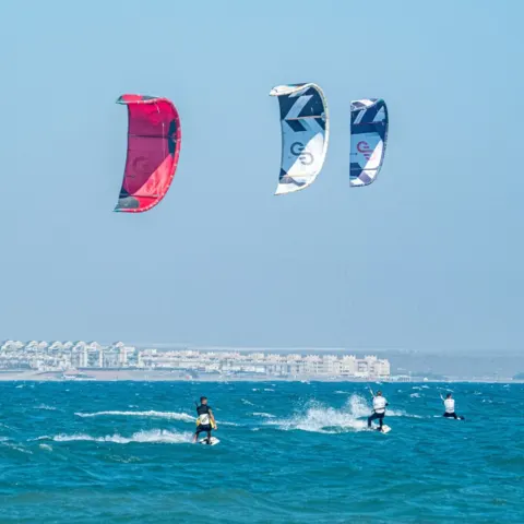 Plusieurs kitesurfeurs sur l'eau