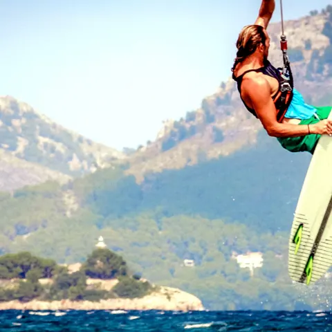 Saut de kitesurf devant des reliefs