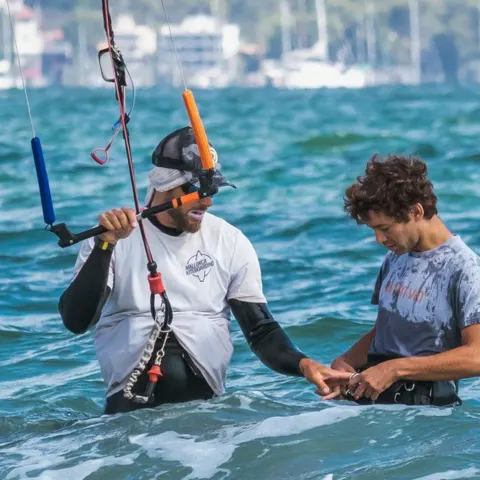 Moniteur et élève de kitesurf dans l'eau