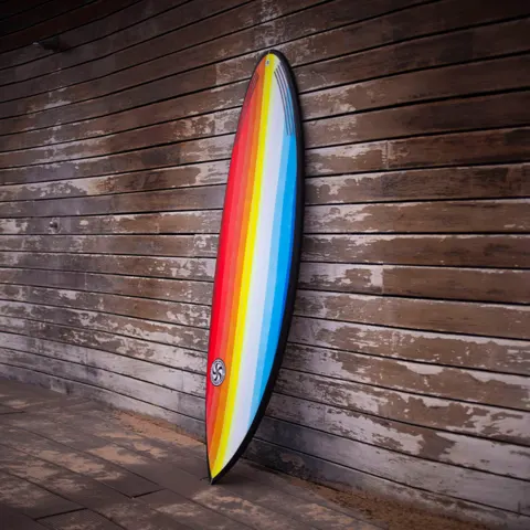 Planche de surf appuyée contre un mur en bois