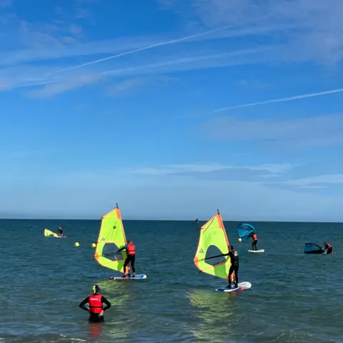 Plusieurs planches à voile près du bord