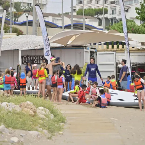 Groupe d'élèves et moniteurs avec leurs planches sur la plage