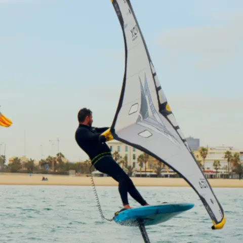 Pratiquant de wingfoil au large d'une plage