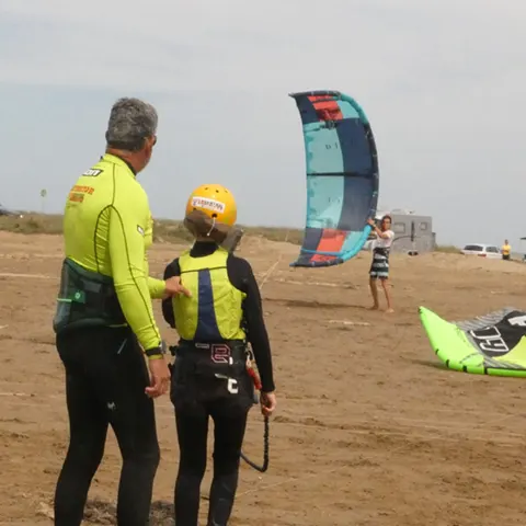 Moniteur et élève sur la plage avec un kite