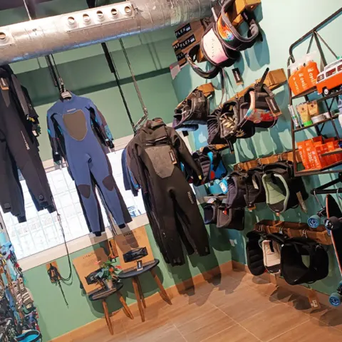 Combinaisons et accessoires exposés en boutique