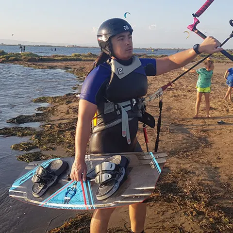 Kitesurfeur avec sa planche au bord de l'eau