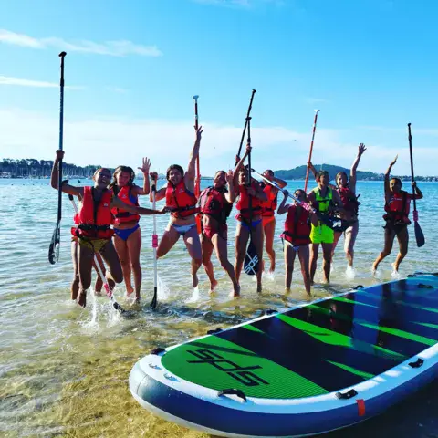Groupe de pagayeurs en gilets sur l'eau peu profonde